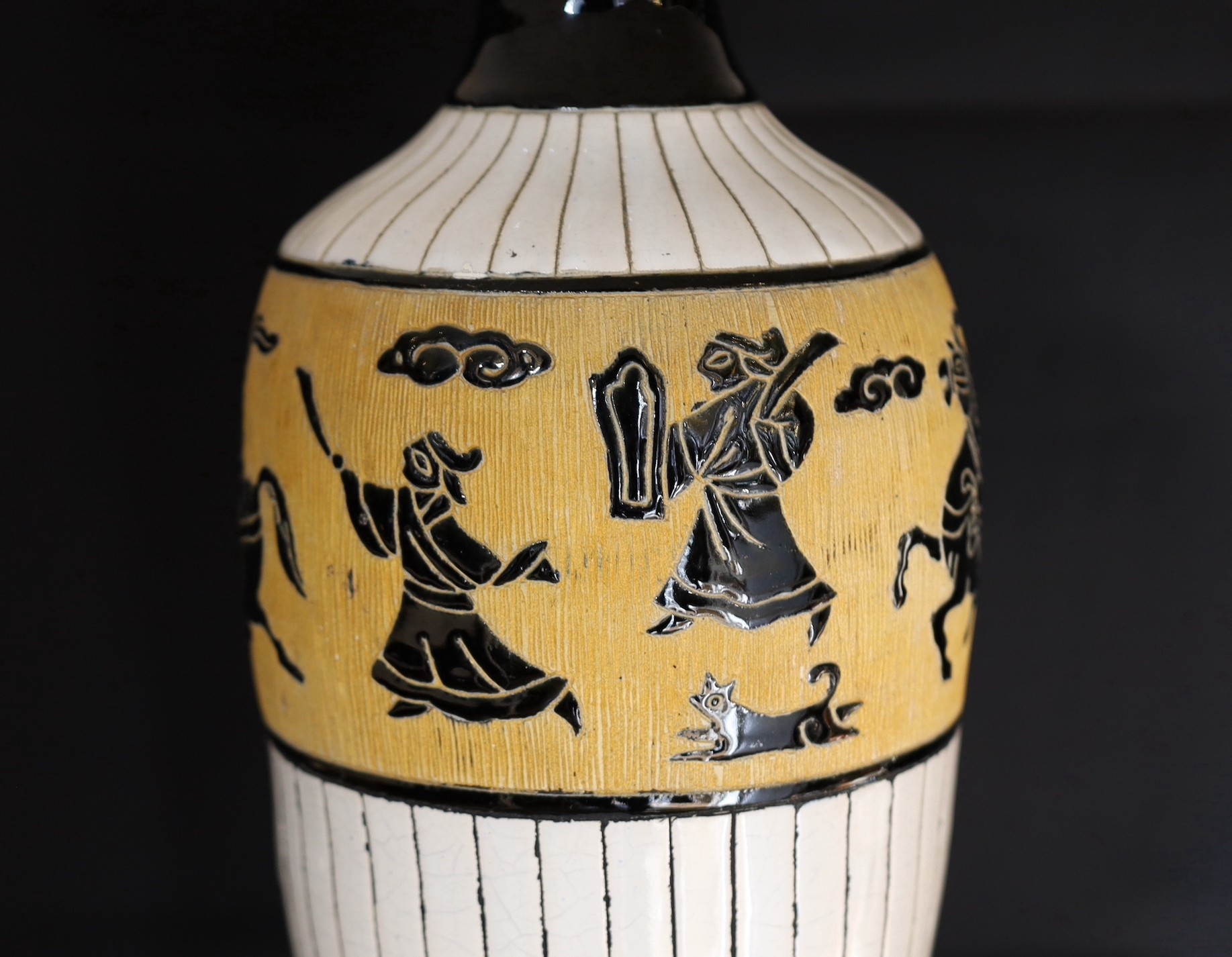 A 20th century Continental tinglazed pottery table lamp, decorated within a band of horse riders and birds, height without shade 62cm